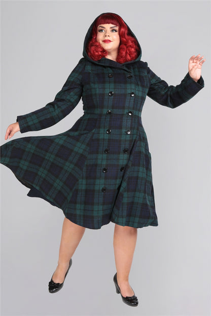 Red haired curvy model wearing a hooded tartan winter coat and black high heels