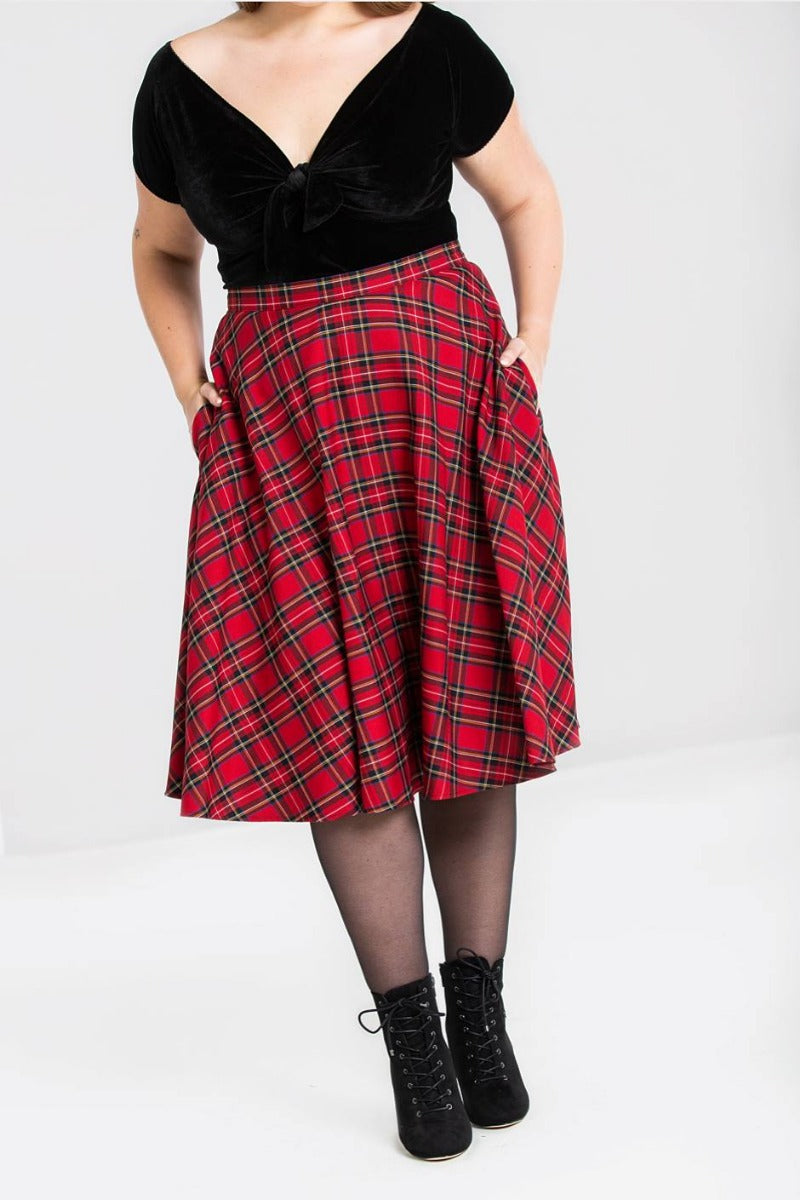 Plus model standing with her hands in her skirt pockets