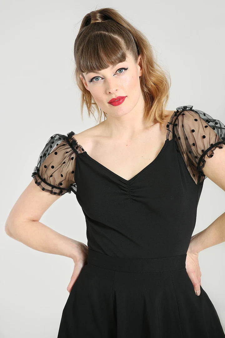 young woman with blonde hair in a ponytail wearing red lipstick standing with her hands on her hips. she is wearing the black Amandine top by Hell Bunny
