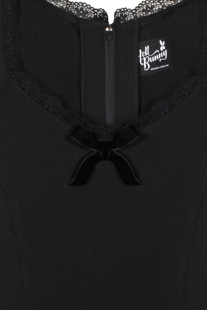Close detail photo of the lace neckline and velvet bow at the front of the black dress 