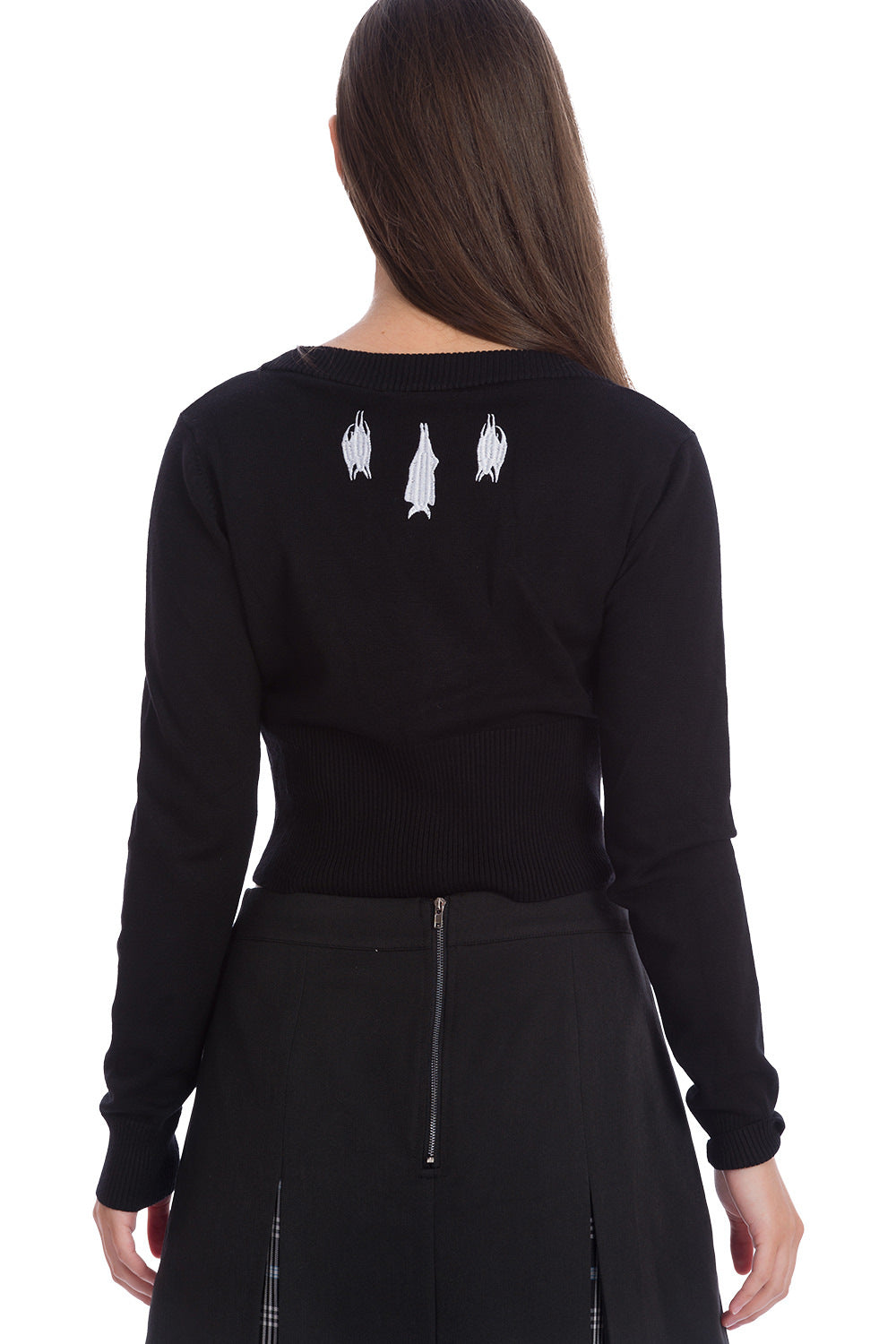 Gothic girl wearing a black long sleeved cardigan with white embroidered hanging bats at the neck