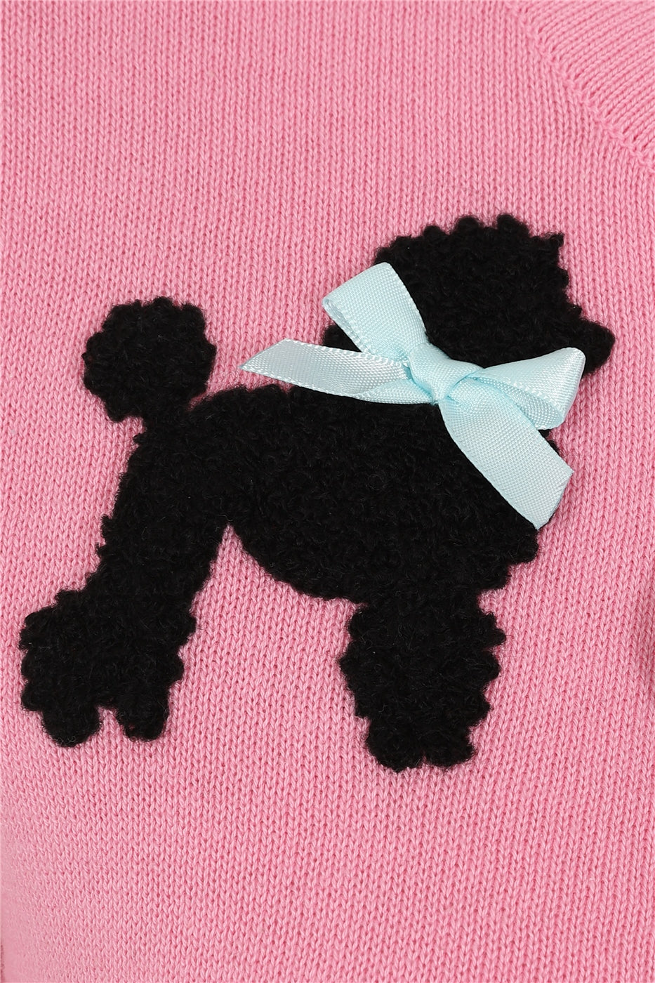 Close up of the fluffy black poodle motif on the Char cardigan. The poodle is finished with a little blue bow around its neck.