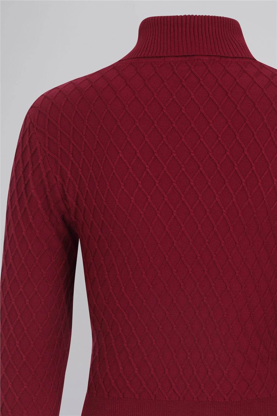 Closeup of lattice knitted jumper. The lattice pattern is diamond shaped and criss crosses diagonally