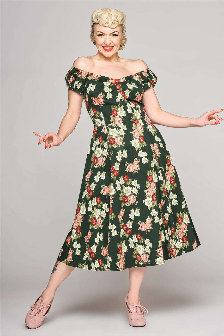 Elegant slim blonde woman smiling and holding her hands out to the sides. She is wearing the Vintage Bloom Dolores Dress and pink heeled shoes