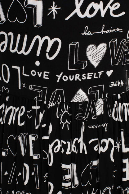 Close up of the white writing that says Love Yourself all over a black background