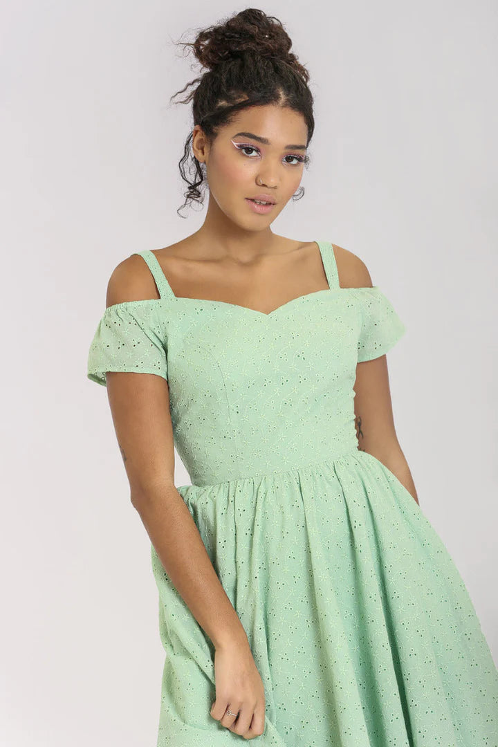 Chic, young woman wearing her hair in a bun and a mint green broderie anglaise fit and flare dress