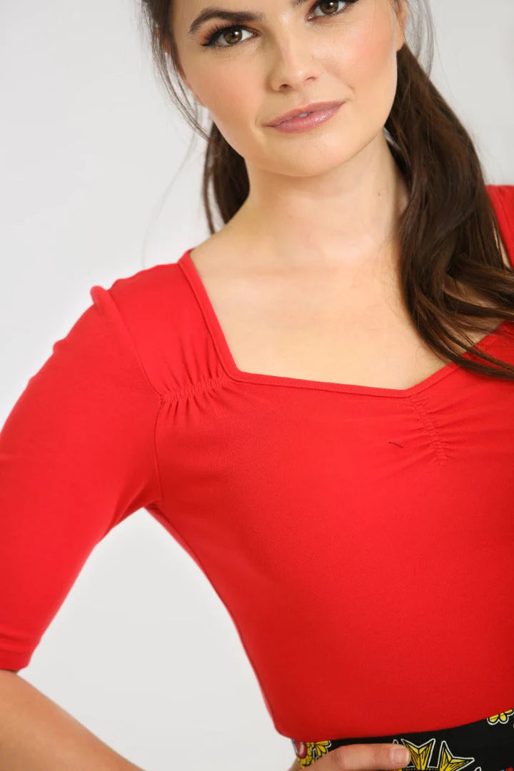 Closeup showing the ruching detail and squared sweetheart neckline on the Philippa Top worn by a brunette model with brown eyes