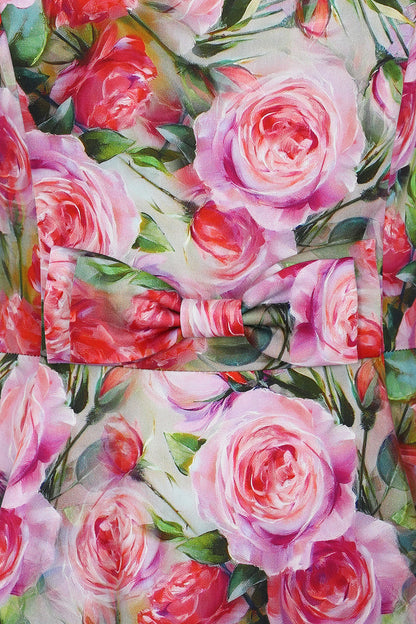 Closeup of the pink rose print and bow at the front waist of the Lola dress