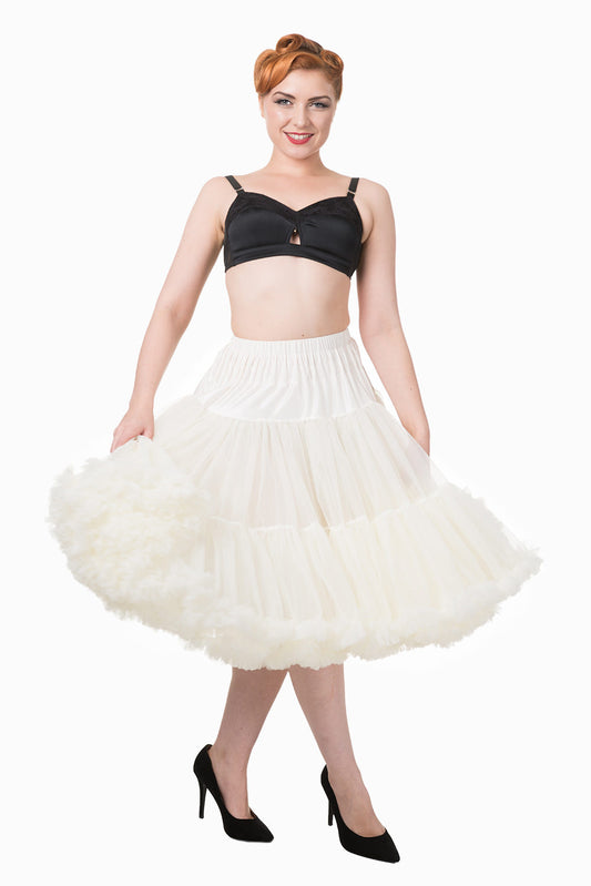 Glamorous vintage model with victory rolls hairstyle wearing a white full petticoat and black high heel shoes