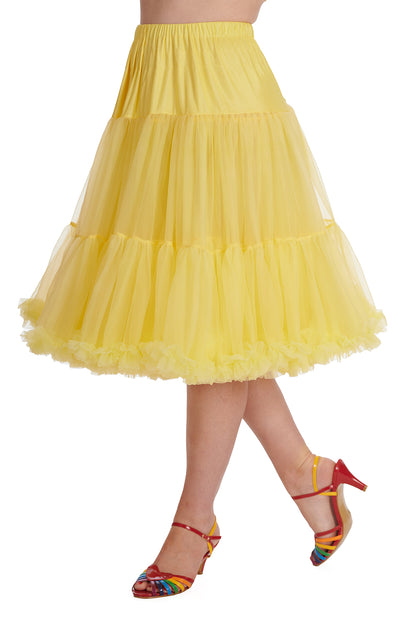 Woman wearing a vibrant yellow full petticoat that drops to just below her knees and rainbow heeled sandals