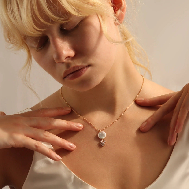 Young woman wearing an 18" length gold chain pearl necklace.