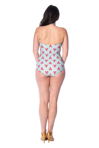 Back view of a woman wearing a strapless, light blue one-piece swimsuit with a red lobster print. The swimsuit features a high-waisted, vintage-inspired design, paired with gold high-heeled shoes.