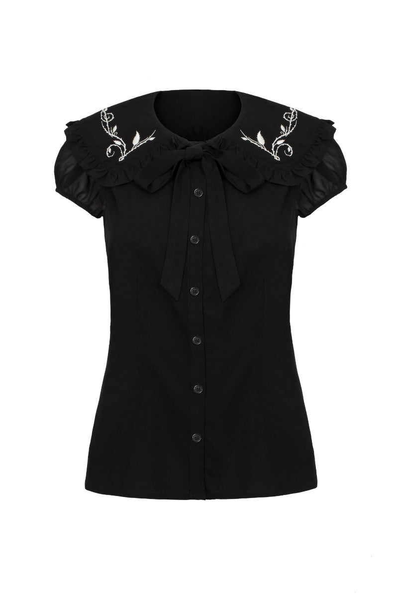 A short-sleeved black blouse with a frill collar and white embroidery, featuring a removable bow tie at the neck.