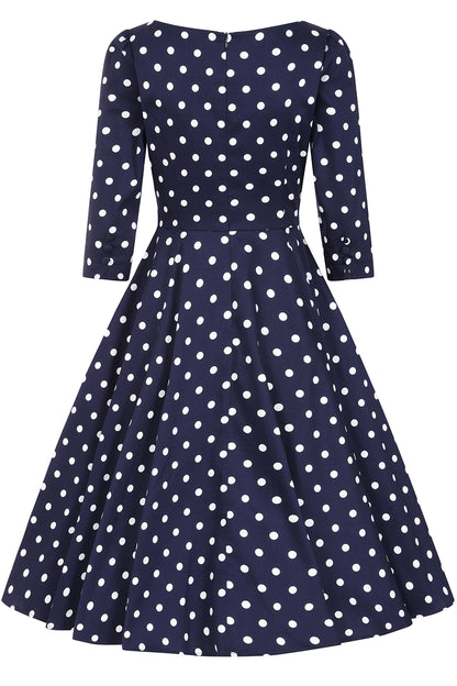 Navy blue dress with white polka dots on a white background