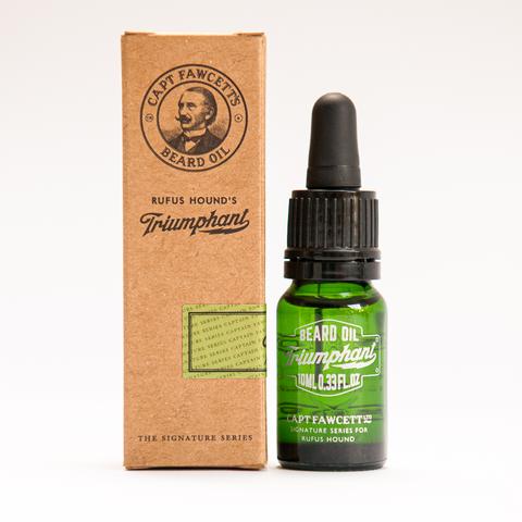 10ML bottle of Triumphant Beard Oil by Captain Fawcett, featuring a green glass bottle with white text and a dropper cap, presented next to its vintage-style brown cardboard packaging displaying the brand logo and Rufus Hound's signature series