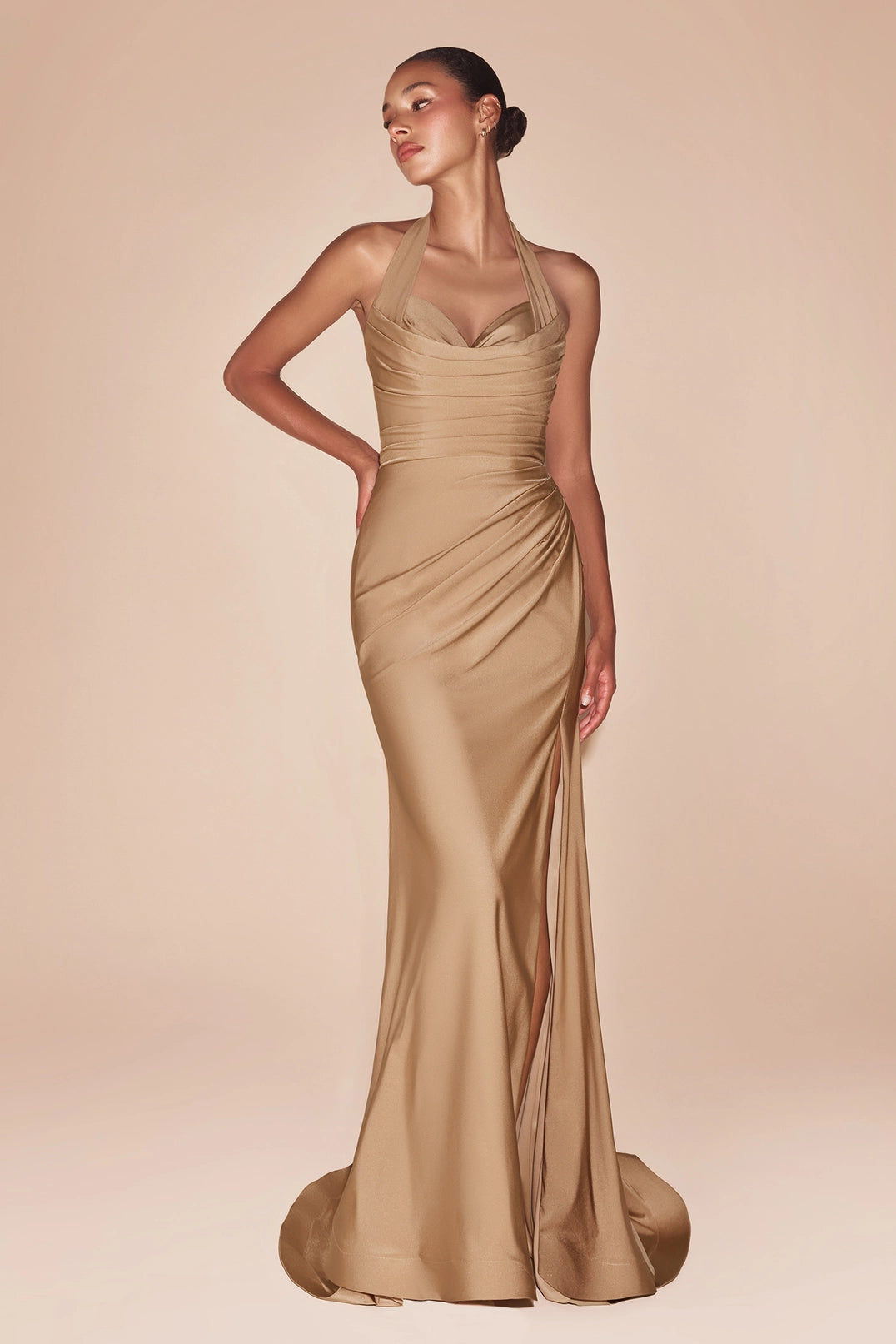 Woman wearing a gold evening gown against a beige background