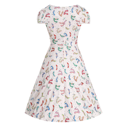 Back view of the Claudia Cream Stiletto Print Swing Dress by Dolly & Dotty, showcasing a playful, colorful stiletto shoe print on a cream background. The dress features short puff sleeves, a fitted bodice, and a flared swing skirt, giving a classic vintage-inspired look from behind.