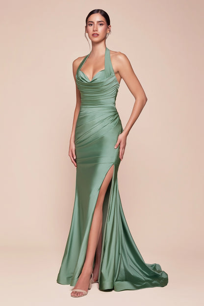 Woman wearing a green evening gown with a high slit on a beige background