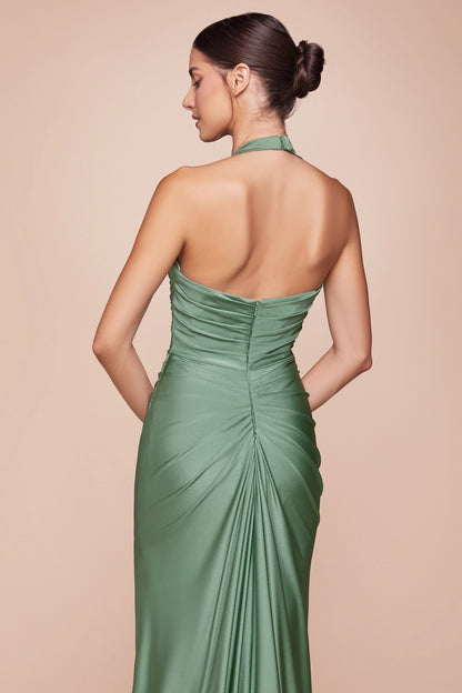 Woman wearing a green halter neck gown against a beige background