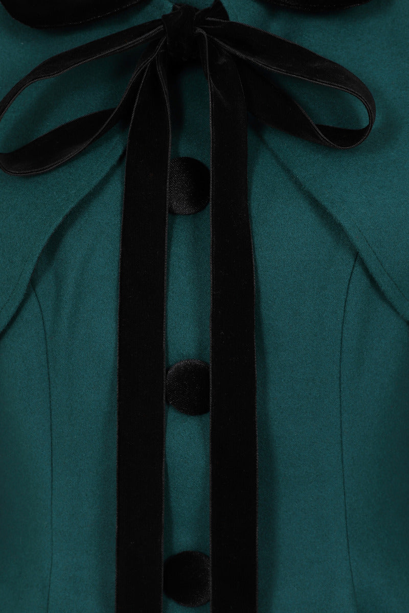 Close up of the velvet bow that ties the Anouk green cape around the coat collar 