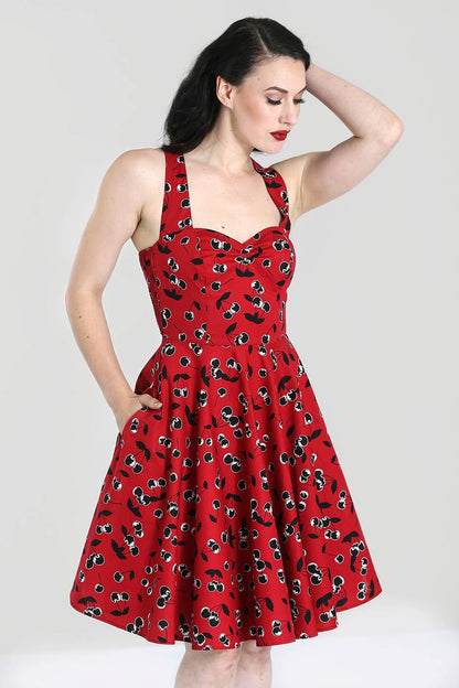 woman with dark hair and fair skin wearing a red cherry print dress with a sweetheart neckline.