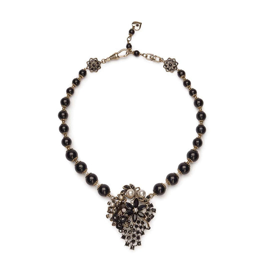 Necklace with black beads and decorative heart-shaped clasp on a white background
