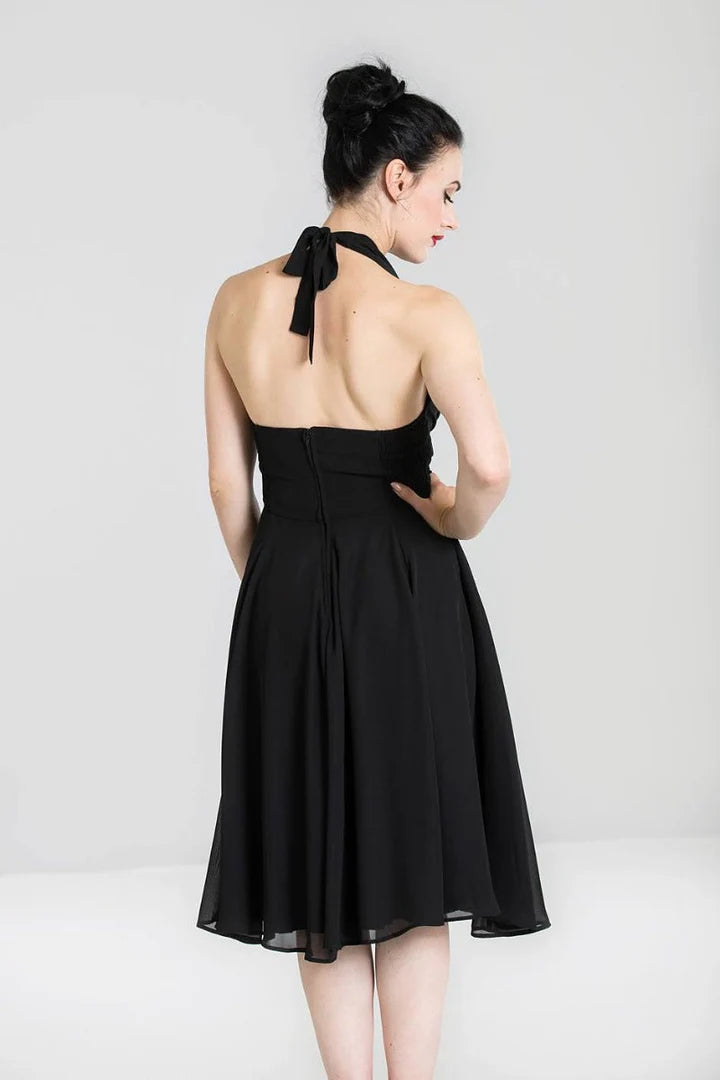 Woman wearing a black halter neck dress against a white background