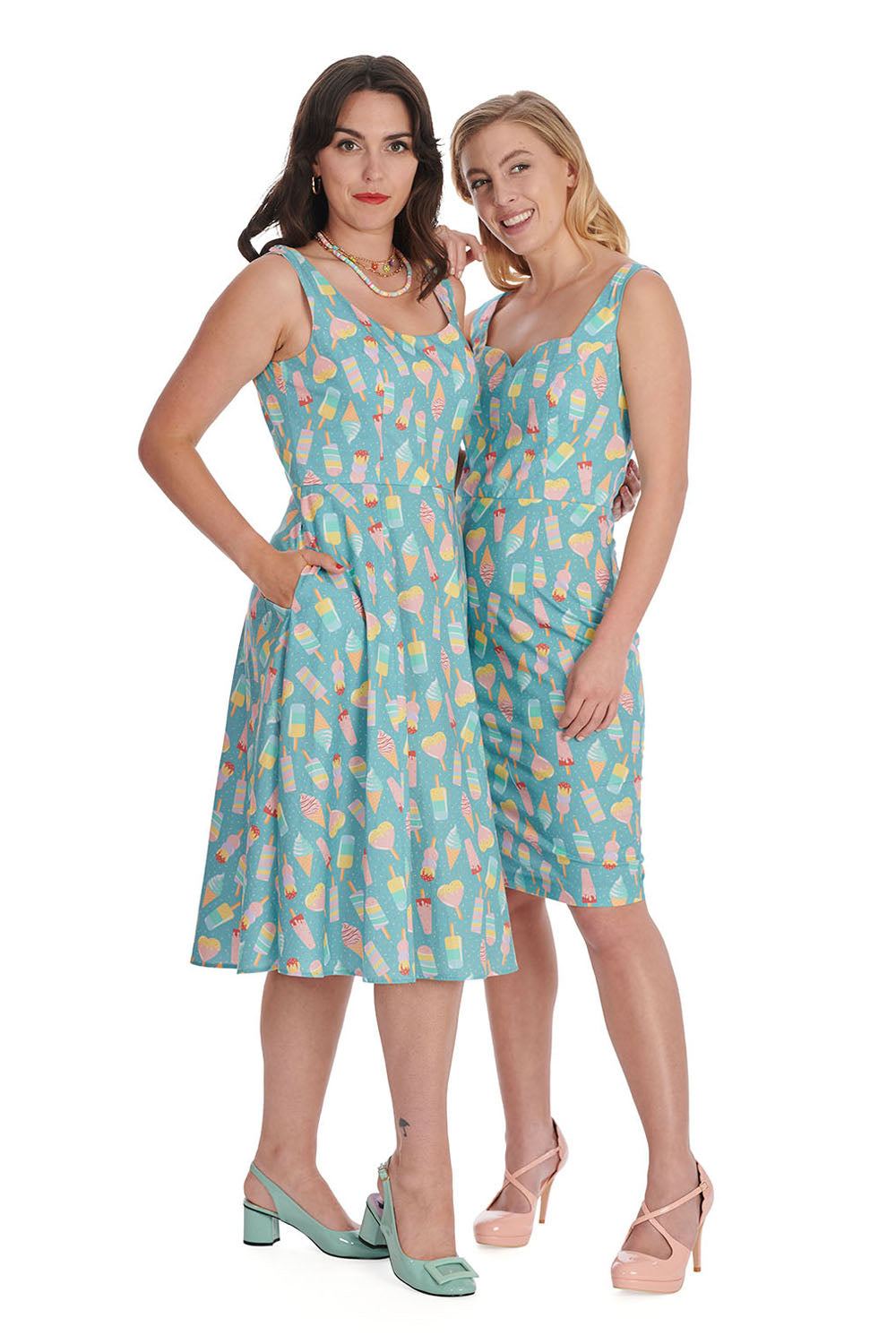 Elegant women standing together smiling wearing light blue ice cream print dresses and heels