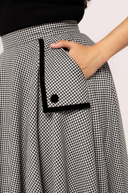 Close up of a woman's hand in the pocket of the Hell Bunny Teddy 50s Skirt, showing the black button and black outline detail on the pocket.