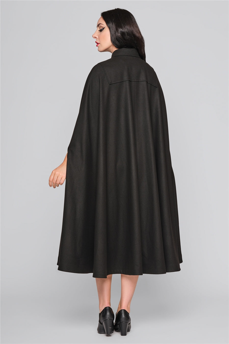 Dark haired woman wearing an elegant long black vintage style cape