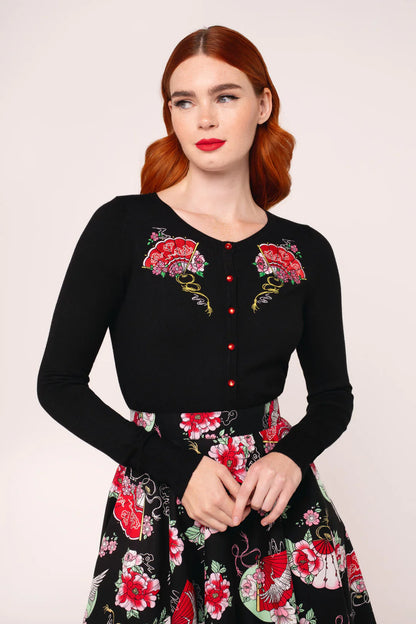 Woman wearing a black dress with floral embroidery on a white background