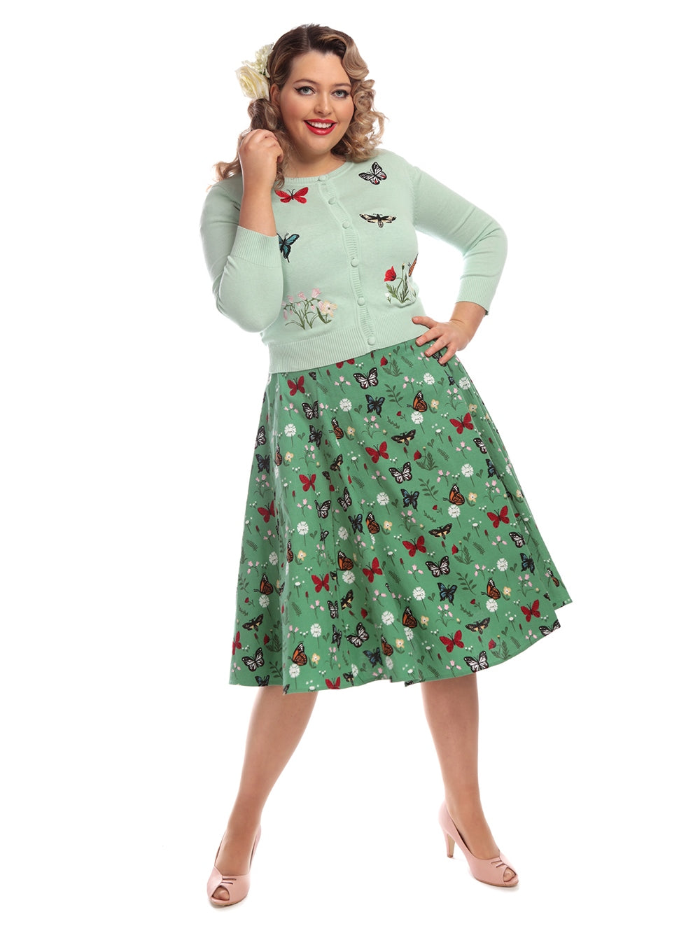 full length shot of a vintage model wearing a 50s inspired butterfly print green skirt and matching cardigan