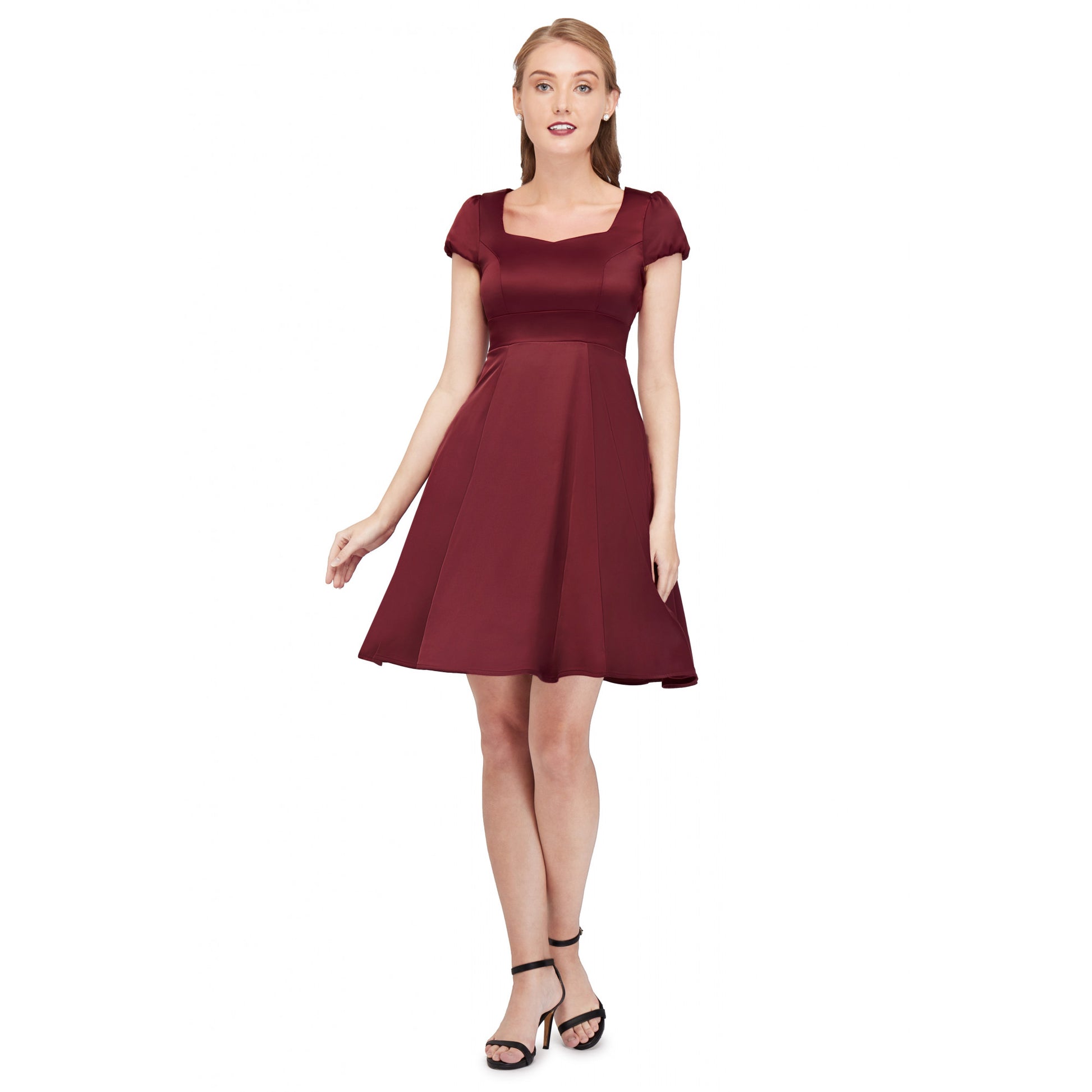 Glamorous woman standing with her hands by her sides wearing the burgundy satin fit and flare "Claudia" dress by Dolly and Dotty.