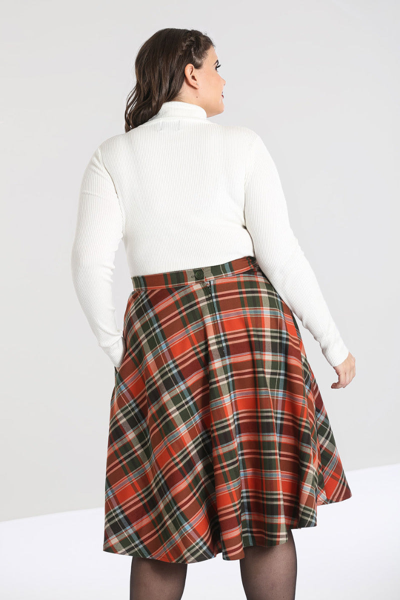 Brunette woman showing the back of the Spiros ivory top by Hell Bunny and a 50s style checked skirt.