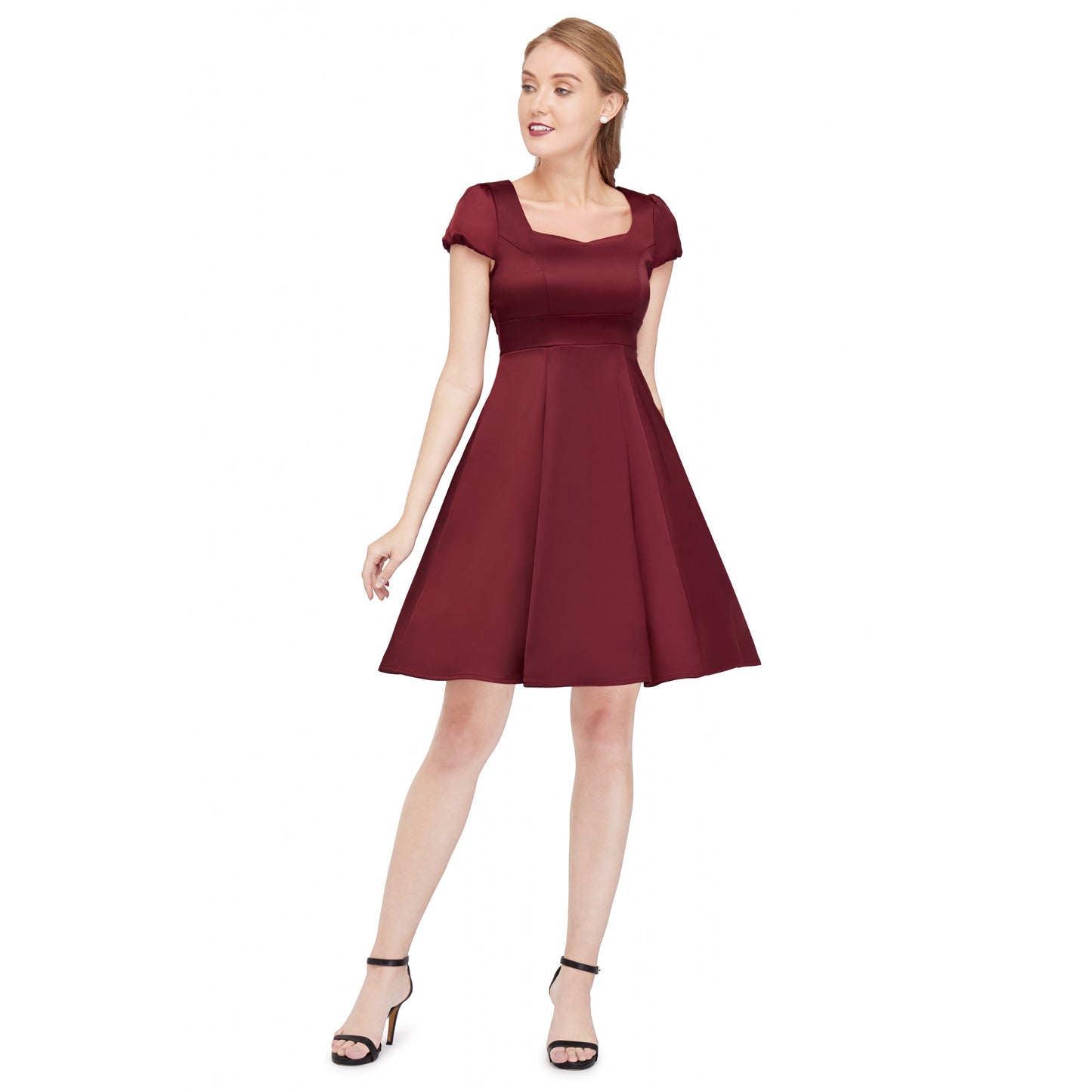 Smiling woman standing wearing the Claudia burgundy satin dress by Dolly and Dotty. The sweetheart neckline and short sleeves flatter the neck and the skirt is hemmed just above the knee.