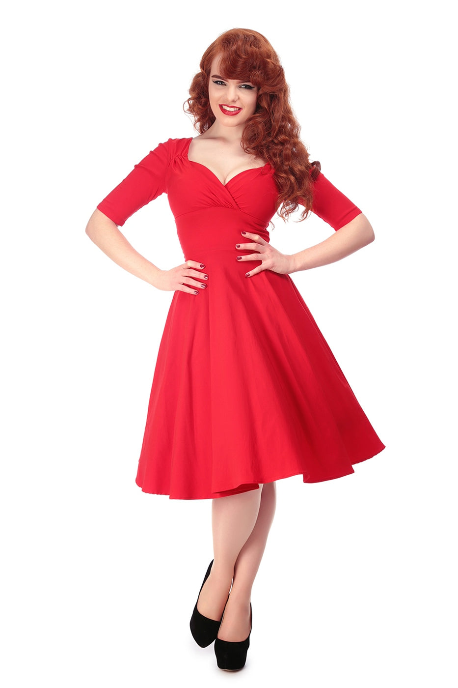 Smiling vintage style model wearing red lipstick, black eyeliner and a red sweetheart neckline swing dress with 1/2 length sleeves