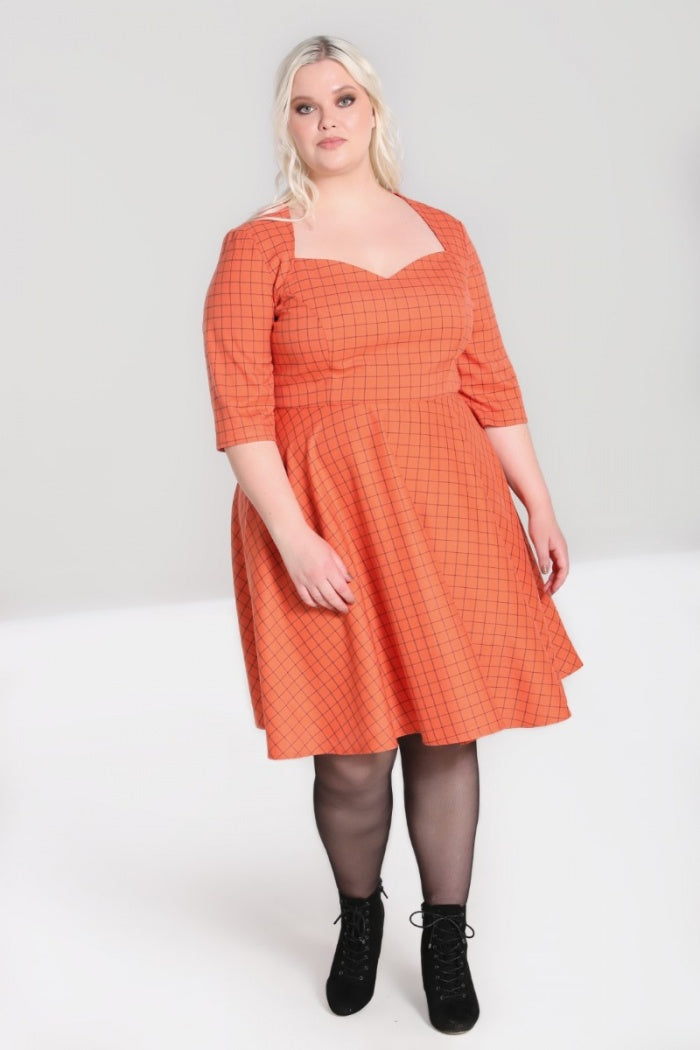 Blonde plus size model wearing an orange checked print dress with 3/4 length sleeves, laceup ankle boots and sheer black tights