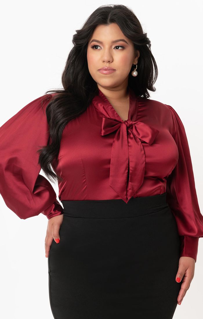 Plus size dark haired tanned model wearing pearl earrings and a l50s inspired long sleeved vintage repro blouse
