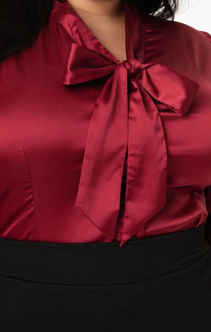 Close up of a pussybow satin burgundy blouse