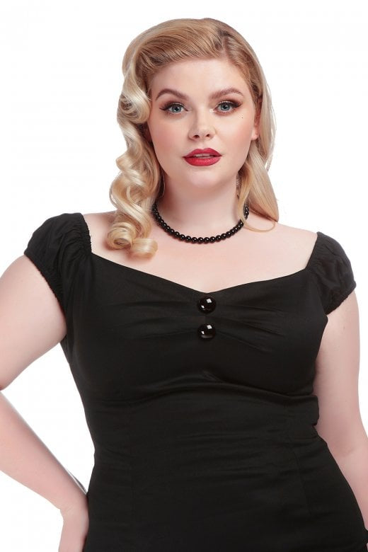 Woman with blonde curled hair and a black bead necklace standing with one hand on her hip wearing the black Dolores top
