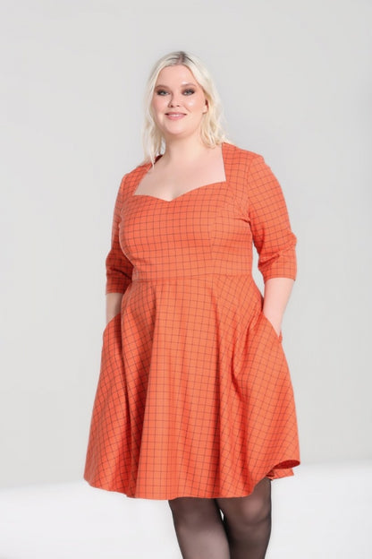 Happy plus size model wearing a 50s inspired orange dress with a sweetheart neckline, 3/4 length sleeves and a flared mid-length skirt