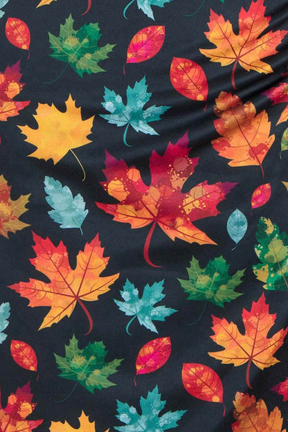 Close up of black fabric with multicoloured Autumn leaves