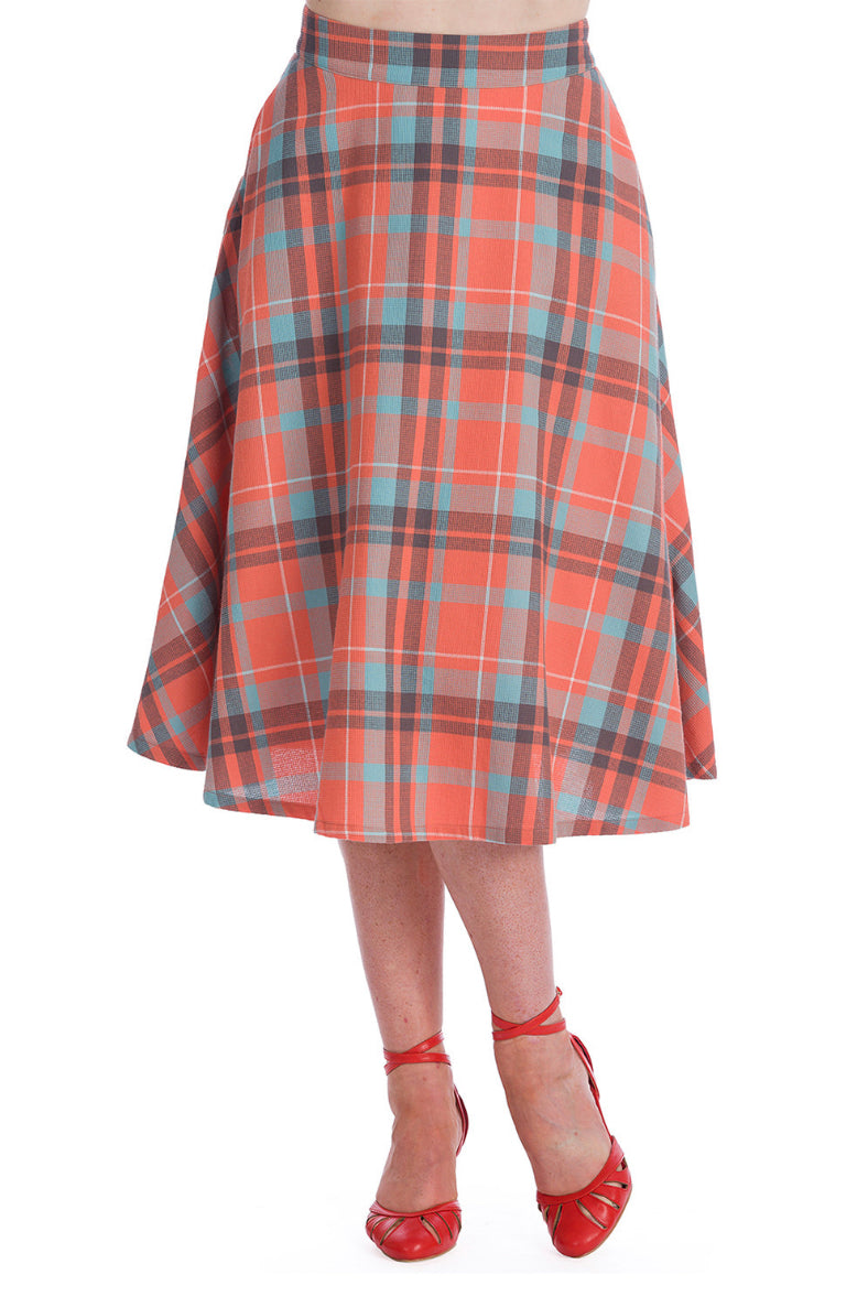 A pretty, rockabilly light orange and blue checked 50s style flare skirt that drops to just below the knee modelled with red strappy heels.